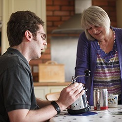 Mental Capacity Act - a brain injured man is supported by his carer as he grinds coffee beans