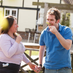A brain injured man and his partner smell flowers whilst gardening, highlighting the importance of smell - which can be lost with a brain injury