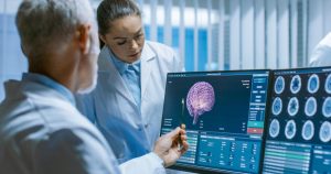 Staff viewing a scanned image of the brain advertising our Neuro-imaging in 2021 webinar