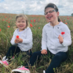 Ella (the subject of our story) and her sister Poppy playing in a field of flowers