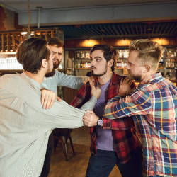 A group of young man tussle aggressively at a bar illustrating criminal injuries and how we can help with Criminal Injuries Compensation Scheme compensation claims