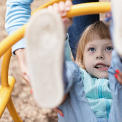 A little girl playing on playground equipment illustrating our article on childhood encephalitis