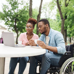 A couple drink coffee whilst reading off a laptop screen illustrating relationships after a brain injury