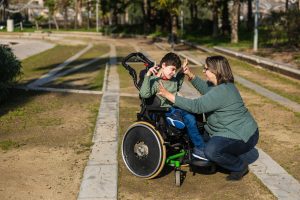 A child with cerebral palsy with his mother in the park